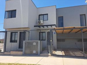 una casa blanca con una puerta y un edificio en MODERNO DUPLEX Con COCHERA en Luzuriaga