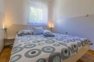 a bedroom with a large bed in a room with a window at One-Bedroom Apartment in Crikvenica XI in Dramalj