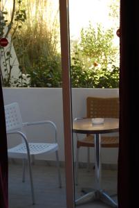 a table and a chair and a table and a window at Artemis Studios in Faliraki