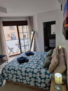 a bedroom with a bed and a view of a balcony at APARTAMENTOS ELEMAR free luggage storage in Málaga
