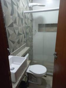a bathroom with a white toilet and a sink at Flat Beverly Hills 101B in Vila Velha +6 photos