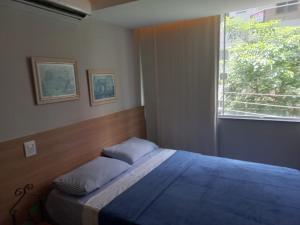 a bedroom with a large bed with a window at Flat Beverly Hills 101B in Vila Velha
