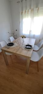 mesa de madera con sillas blancas y comedor en Casa La Torre, en Cepeda
