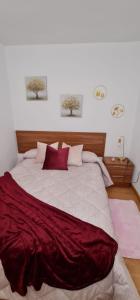 um quarto com uma cama grande e lençóis vermelhos em Casa La Torre em Cepeda