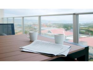 uma mesa com duas chávenas de café e um jornal em Lieta Nakayama - Vacation STAY 22439v em Nago