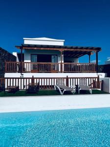 a house with two chairs and a swimming pool at Casa Sueños in Playa Blanca
