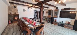 a long dining room with a long table and chairs at Cabana Floare de Colt 2 in Râşnov