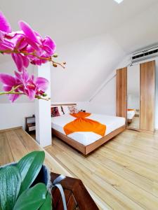 um quarto com uma cama com um cobertor laranja em Hotel Veronica em Eforie Nord