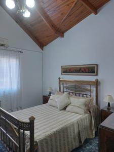 a bedroom with a large bed with a wooden ceiling at La Porota in Ramallo