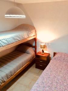 - une chambre avec des lits superposés et une table avec une lampe dans l'établissement Casa en Tilcara con hermosa vista al Pucara, à Tilcara