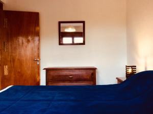 1 dormitorio con cama, tocador y espejo en Casa en Tilcara con hermosa vista al Pucara en Tilcara