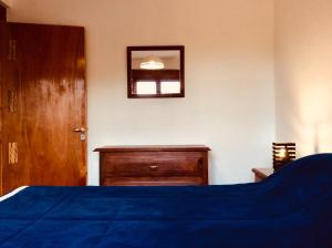 a bedroom with a bed and a dresser and a mirror at Casa en Tilcara con hermosa vista al Pucara in Tilcara