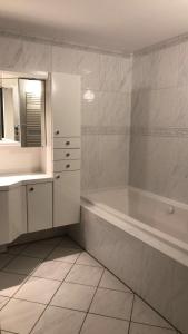 een witte badkamer met een bad en een wastafel bij Grutsk op 12 in Drachten