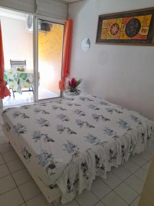 a bed sitting in a room with a window at Appartement idéal famille, vue sur mer. in Le Moule