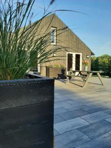 un edificio con una mesa y un banco en un patio en Grutsk op 12, en Drachten