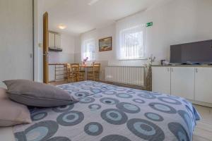 a bedroom with a bed and a kitchen with a table at One-Bedroom Apartment in Crikvenica I in Dramalj