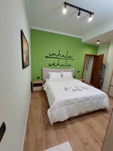 1 dormitorio con 1 cama grande y pared verde en Feel at home ap1, en Tirana