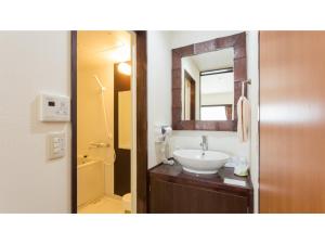 ein Bad mit einem Waschbecken und einem Spiegel in der Unterkunft Hachijojima Hotel Resort Sea Pillows - Vacation STAY 53160v in Mitsune