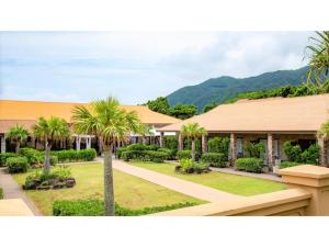 ein Haus mit Palmen und einem Gebäude in der Unterkunft Hachijojima Hotel Resort Sea Pillows - Vacation STAY 53160v in Mitsune