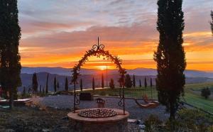 a sunset with an arch in a park with a bench at Casa al Maestro B&B in Radicofani