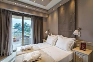 a bedroom with a large bed with towels on it at Kassandra Village Resort in Pefkohori +111 photos