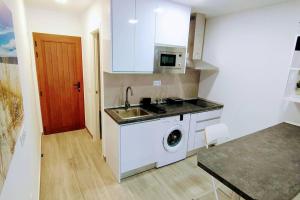 a kitchen with a sink and a washing machine at Sunshine 435 in Playa del Ingles