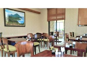 ein Esszimmer mit Holztischen und -stühlen in der Unterkunft Hachijojima Hotel Resort Sea Pillows - Vacation STAY 53193v in Mitsune