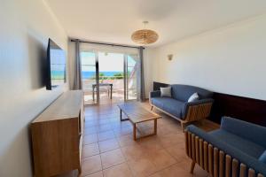 un soggiorno con un divano e un tavolo di KALIA LODGE a Sainte-Anne