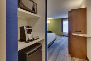 a hotel room with a bed and a kitchen at Holiday Inn Express & Suites Atlanta Perimeter Mall Hotel, an IHG Hotel in Sandy Springs