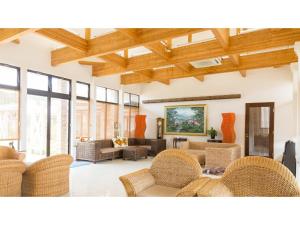 un salon avec des meubles en osier et des fenêtres dans l'établissement Hachijojima Hotel Resort Sea Pillows - Vacation STAY 53308v, à Mitsune