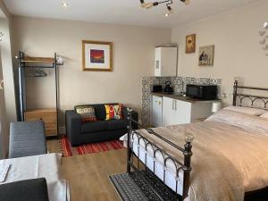 a bedroom with a bed and a couch and a kitchen at Studio 2 in Matlock