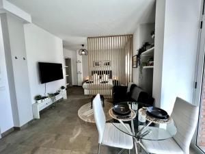 salon ze stołem, krzesłami i telewizorem w obiekcie Loft moderno en buena ubicación w mieście Terrassa