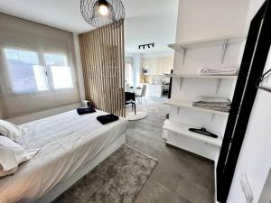 a bedroom with a white bed and a dining room at Loft moderno en buena ubicación in Terrassa