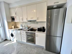 kuchnia z białymi szafkami i lodówką ze stali nierdzewnej w obiekcie Loft moderno en buena ubicación w mieście Terrassa +10 zdjęć