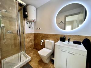 uma casa de banho com um WC, um lavatório e um espelho. em Loft moderno en buena ubicación em Terrassa