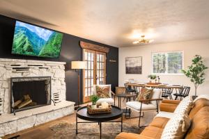 a living room with a fireplace and a tv on the wall at The Modern Mountaineer in Bailey