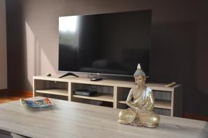 a statue sitting on a table in front of a tv at Apartamento complejo residencial in Las Palmas de Gran Canaria