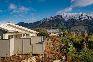 a house with a fence in front of a mountain at Lakeview in Lake Hawea