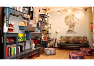 a living room with a couch and bookshelves at Selina Parque 93 Bogota in Bogotá