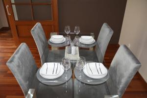una mesa de comedor con sillas y copas de vino. en Apartamento complejo residencial, en Las Palmas de Gran Canaria
