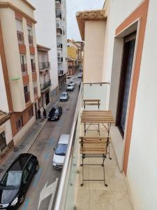 a balcony with a table and chairs on a city street at APARTAMENTOS ELEMAR free luggage storage in Málaga