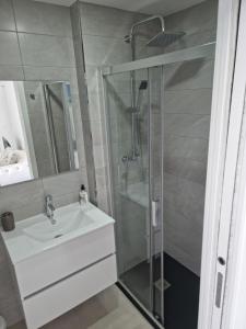a bathroom with a white sink and a shower at APARTAMENTOS ELEMAR free luggage storage in Málaga