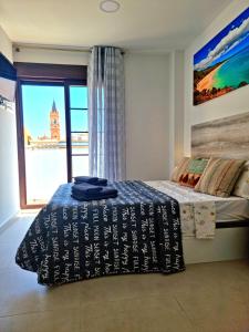 a bedroom with a bed and a large window at APARTAMENTOS ELEMAR free luggage storage in Málaga