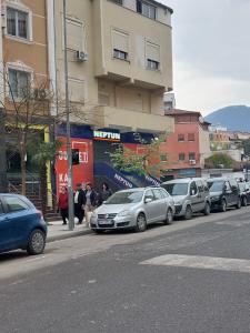 una fila de autos estacionados al lado de una calle en Feel at home ap1, en Tirana