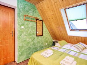 Dom Wczasowy Na Kamieńcu في بيالكا تاترزانسكا: غرفة نوم عليها سرير وفوط