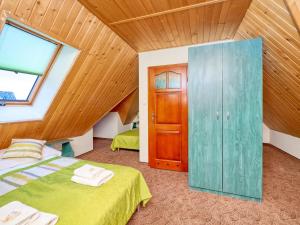 1 dormitorio con cama verde y techo de madera en Dom Wczasowy Na Kamieńcu, en Białka Tatrzanska