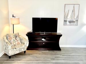 een woonkamer met een tv en een stoel bij Golf Colony Resort 36F in Myrtle Beach