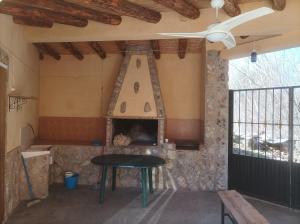 a stove in a room with a table and a fireplace at casas rurales ivan el penas 3 in Letur