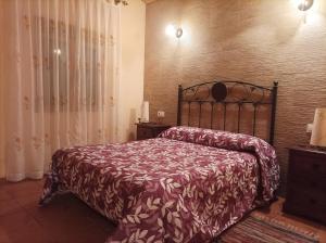 a bedroom with a bed with a red bedspread at casas rurales ivan el penas 3 in Letur