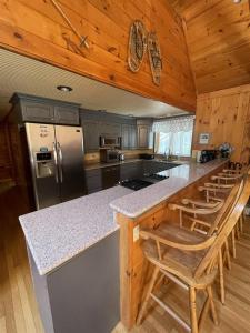 a kitchen with a counter and some wooden cabinets at GOOD TIMES CHALET LIMIT 19 chalet in Bridgton +16 photos